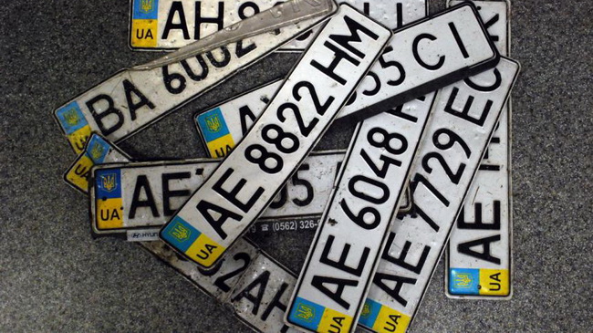 Несколько десятков номерных знаков потеряли автомобилисты в луже под мостом в Каменском